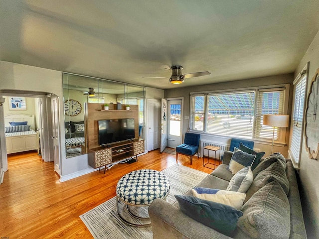 living room featuring radiator heating unit, hardwood / wood-style floors, and ceiling fan