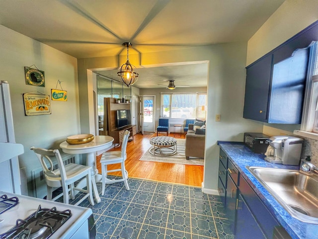 kitchen featuring pendant lighting, sink, ceiling fan, dark hardwood / wood-style floors, and blue cabinets