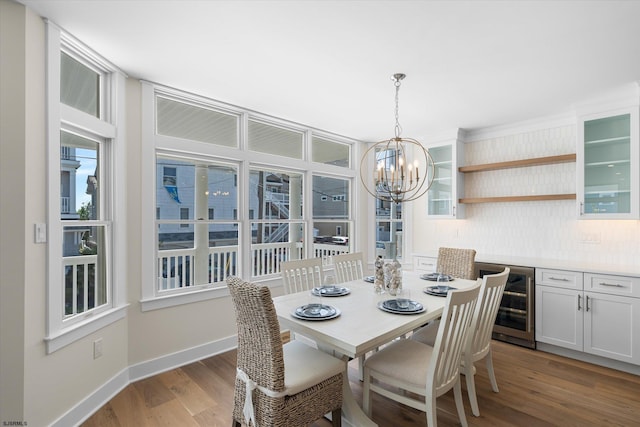 dining room with a notable chandelier, wood-type flooring, and wine cooler