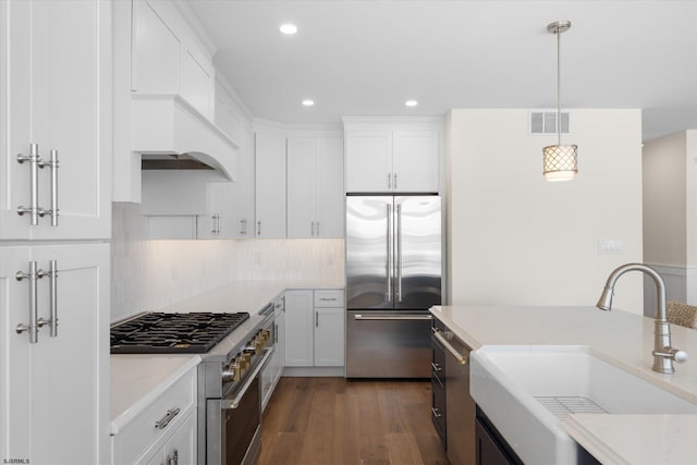 kitchen featuring high end appliances, white cabinetry, and dark hardwood / wood-style floors