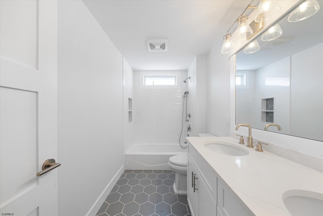 full bathroom featuring tile patterned flooring, vanity, toilet, and tiled shower / bath combo