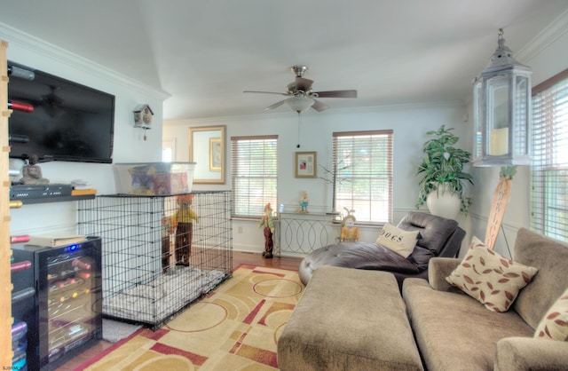 living room with ornamental molding, light wood-type flooring, and ceiling fan