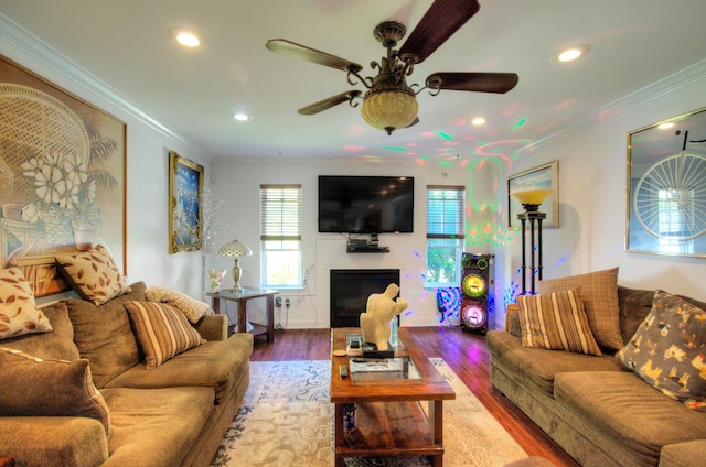 living room with ornamental molding, wood-type flooring, and ceiling fan