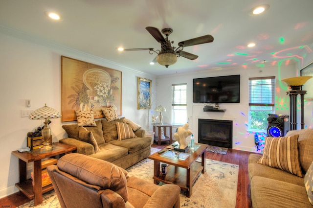 living room with hardwood / wood-style floors, ceiling fan, and crown molding