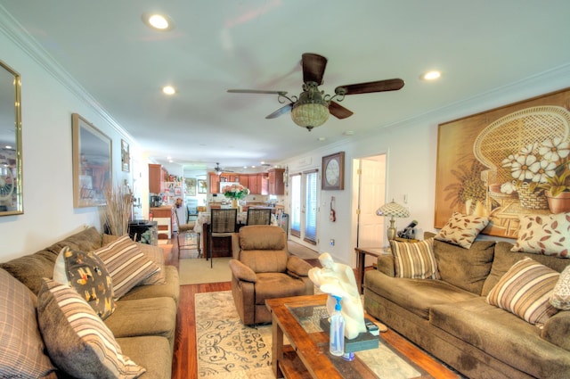 living room with ceiling fan, crown molding, and light hardwood / wood-style flooring