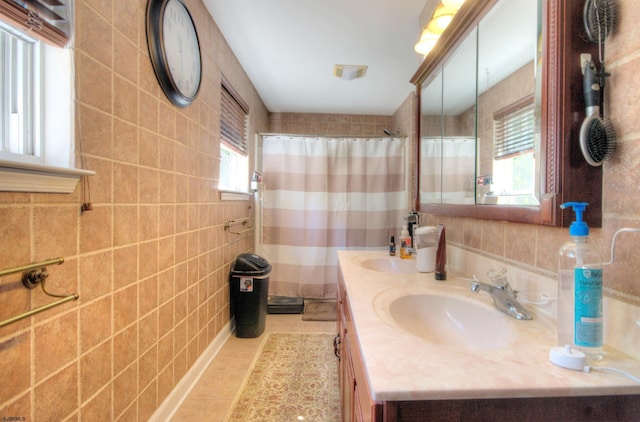 bathroom featuring tile patterned floors, tile walls, vanity, and a healthy amount of sunlight