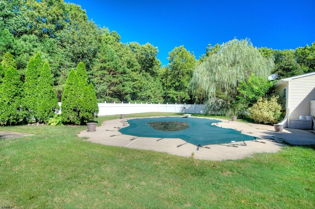 view of swimming pool with a patio area, a yard, and a diving board