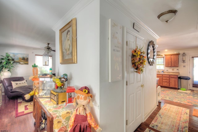 corridor with ornamental molding and light hardwood / wood-style floors