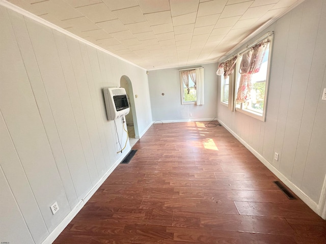 interior space with ornamental molding, dark hardwood / wood-style flooring, and heating unit