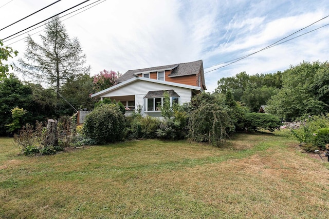 view of side of home with a yard