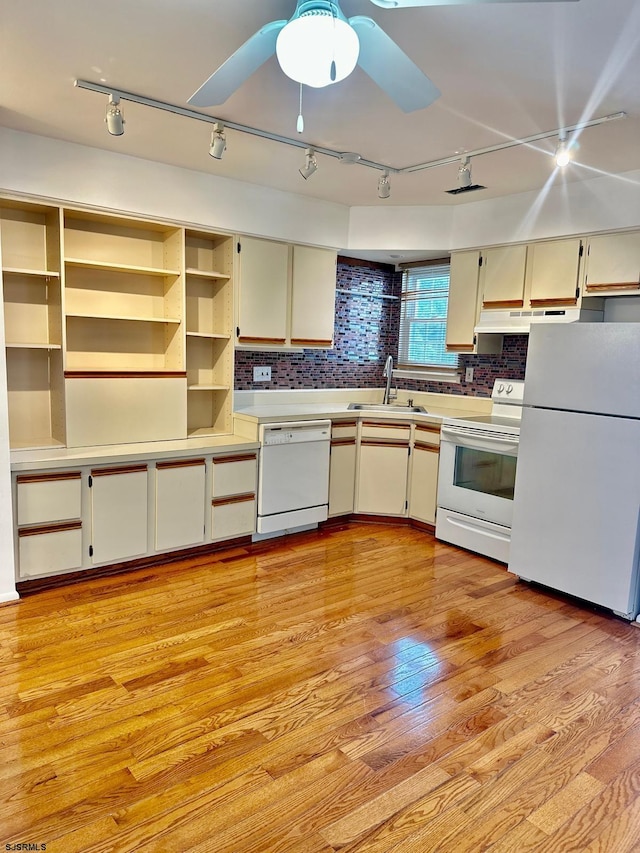 kitchen with light wood-type flooring, white appliances, backsplash, sink, and ceiling fan