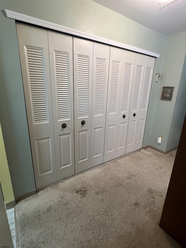 unfurnished bedroom with a closet, baseboards, and carpet