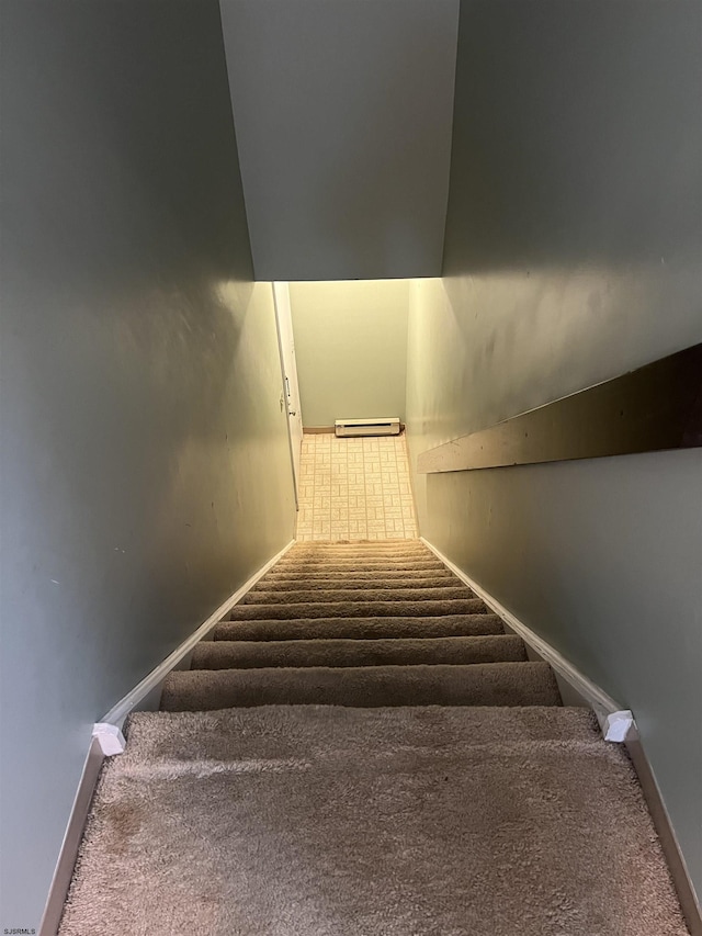 stairs featuring baseboards, baseboard heating, and carpet flooring