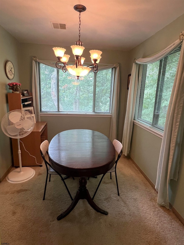 carpeted dining space with a chandelier