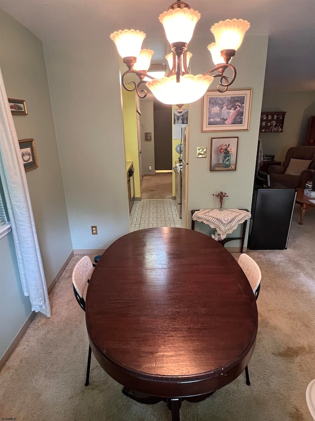 dining area featuring light colored carpet and an inviting chandelier