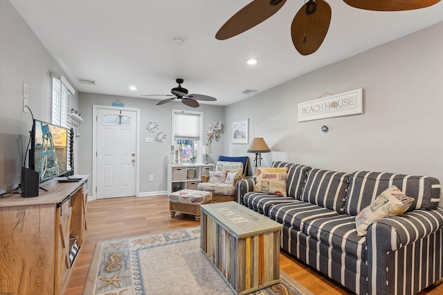 living room featuring light hardwood / wood-style flooring and ceiling fan