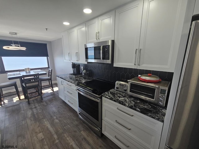 kitchen with stainless steel appliances, dark hardwood / wood-style flooring, and white cabinetry