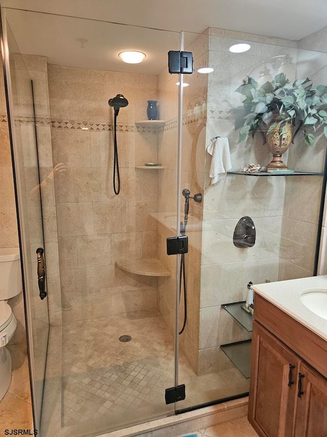 bathroom with vanity, toilet, and a shower with shower door