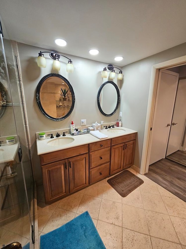 bathroom featuring vanity, hardwood / wood-style flooring, and a shower with shower door