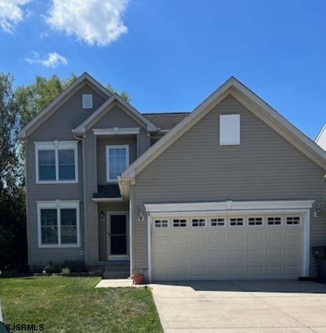 view of front of home with a garage and a front lawn