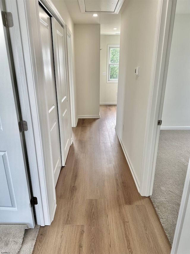 corridor featuring recessed lighting, baseboards, attic access, and wood finished floors