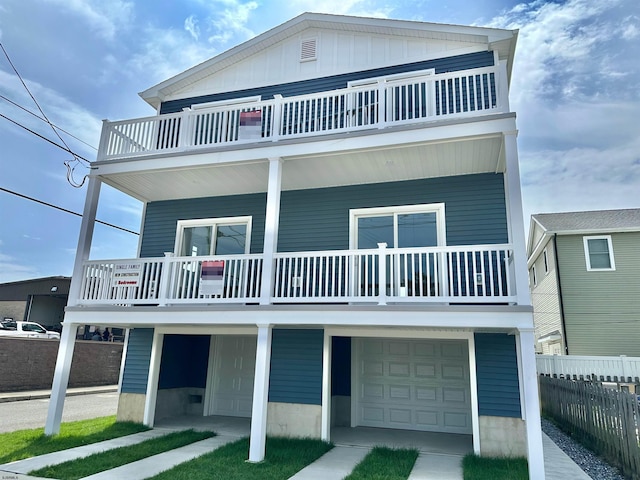 raised beach house featuring a balcony and a garage