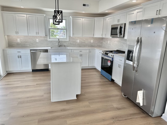 kitchen featuring visible vents, light wood-style flooring, a sink, white cabinetry, and appliances with stainless steel finishes