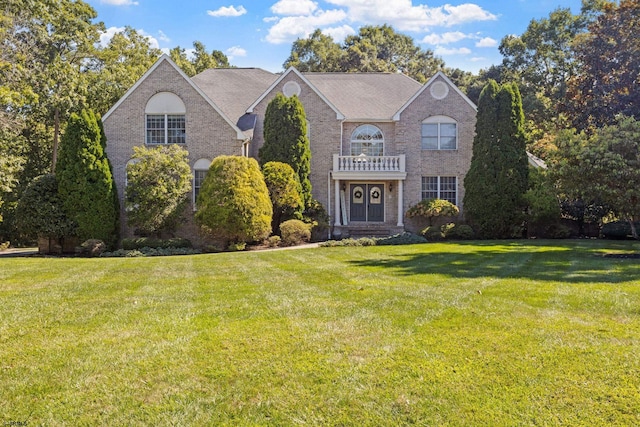 front facade featuring a front yard and a balcony