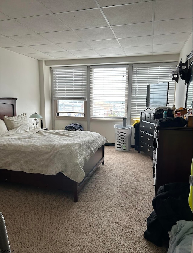 carpeted bedroom with a paneled ceiling