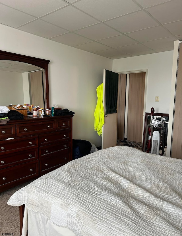 bedroom featuring carpet and a drop ceiling