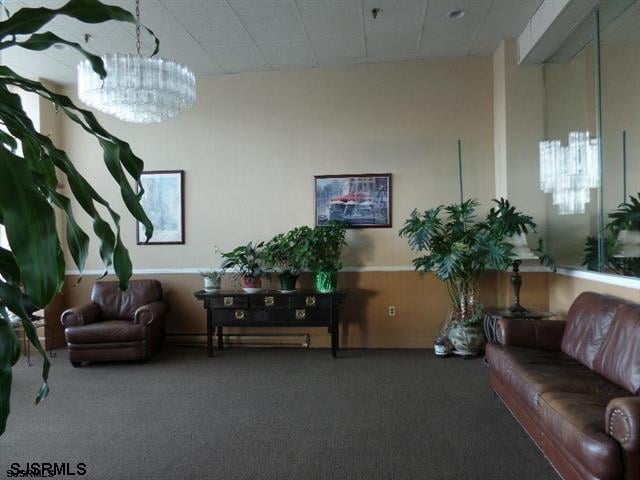 carpeted living room with an inviting chandelier