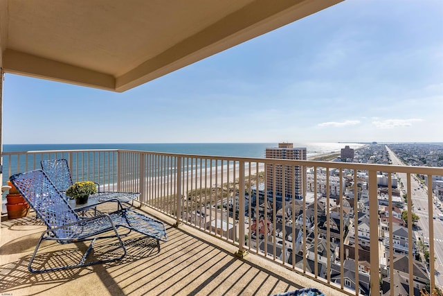 balcony featuring a view of the beach and a water view