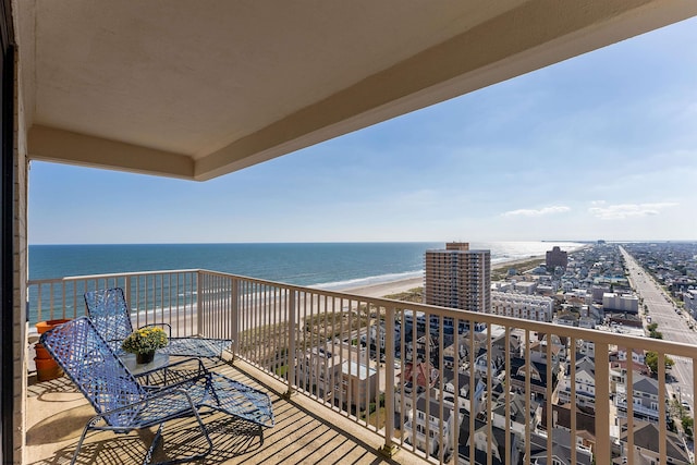 balcony featuring a beach view and a water view