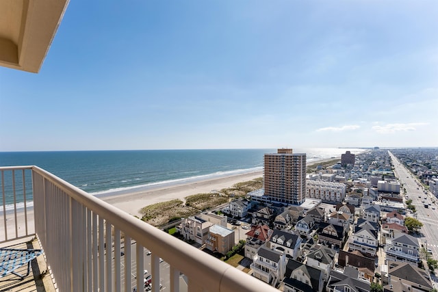 balcony with a water view and a view of the beach