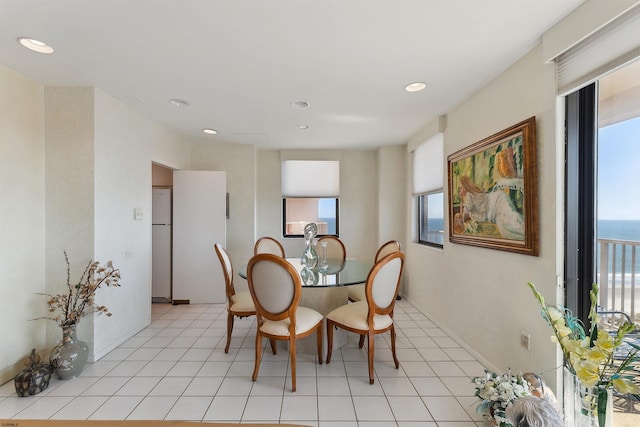 dining area featuring a water view and light tile patterned flooring