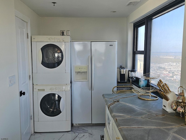 laundry area featuring a healthy amount of sunlight and stacked washer / drying machine