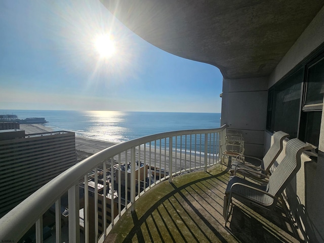 balcony featuring a beach view and a water view