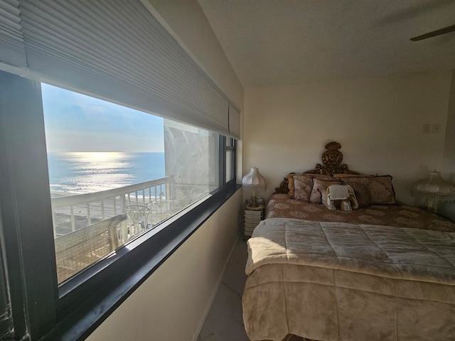 bedroom featuring a water view and a beach view