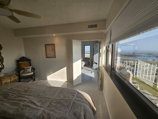 bedroom with a textured ceiling and ceiling fan