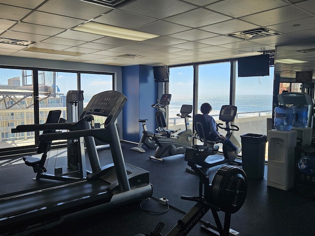 workout area with a paneled ceiling and a wealth of natural light