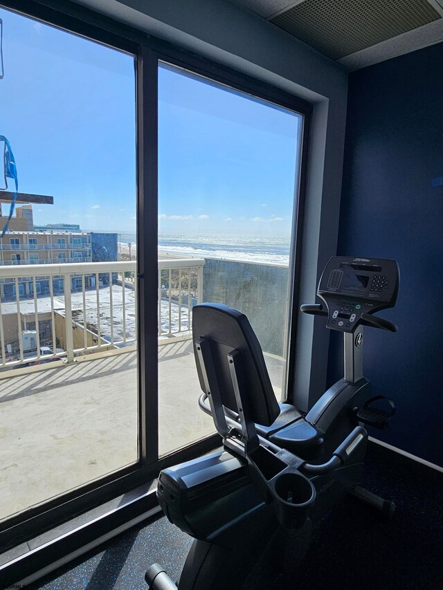 workout area with a beach view and a water view