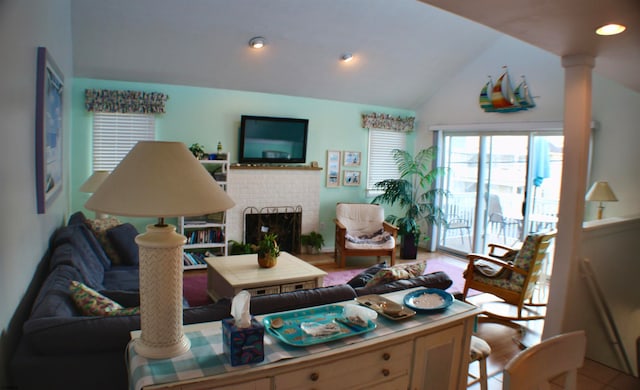 living room with lofted ceiling and a brick fireplace