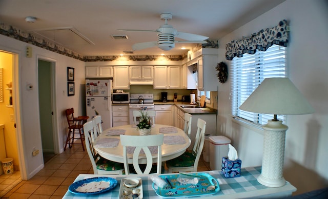 dining space featuring ceiling fan, light tile patterned floors, and sink