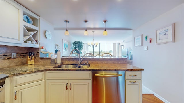 kitchen featuring light stone countertops, decorative light fixtures, stainless steel dishwasher, and sink