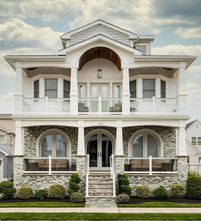 view of front of property with a balcony and french doors