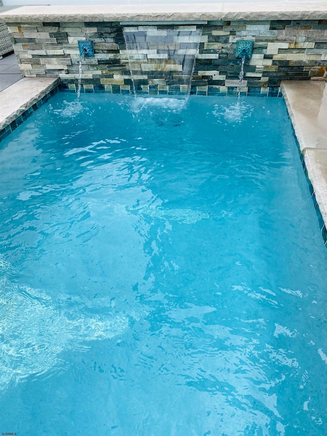 view of swimming pool featuring pool water feature