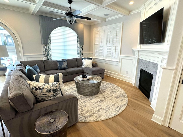 living room featuring ceiling fan, a fireplace, light hardwood / wood-style floors, and a healthy amount of sunlight