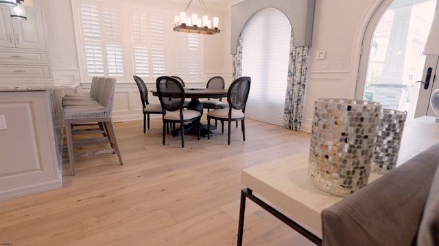 dining space featuring a wealth of natural light, crown molding, and light hardwood / wood-style floors