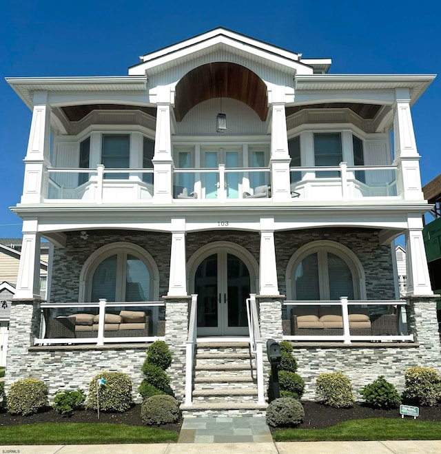 view of front of home with a balcony and french doors