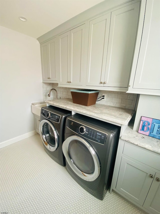 laundry room featuring cabinets, washer and dryer, and sink